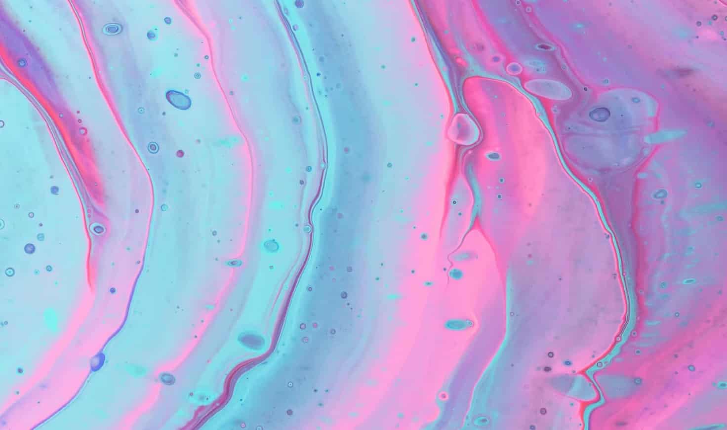 Iridescent ripples of a bright blue and pink liquid.